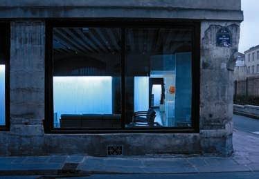 View of the window with the back-lighted fringe curtains lighted in blue